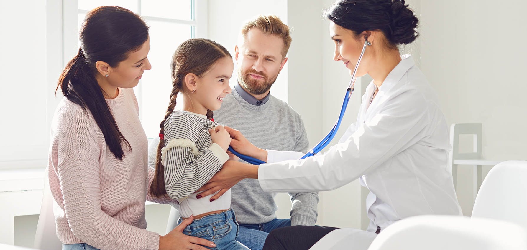 Happy family on a visit to the doctor in the office of a doctor.